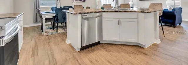 a kitchen with a sink a refrigerator and wooden floor