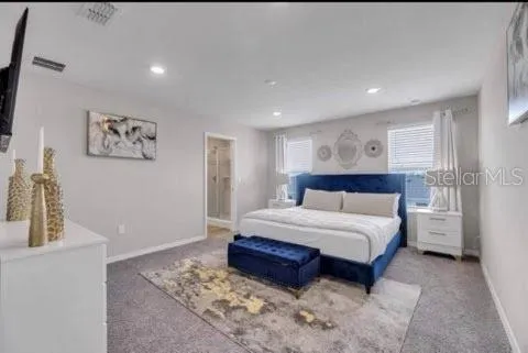 a spacious bedroom with a large bed and a chandelier