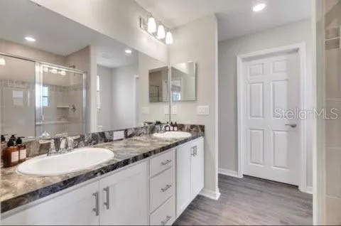 a bathroom with double sink and a mirror