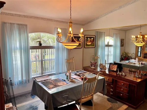 a dining room with wooden floor and chandelier