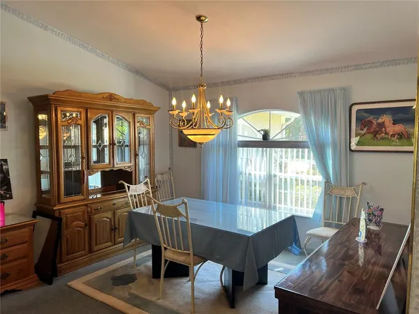 a view of a dining room with furniture a chandelier and window
