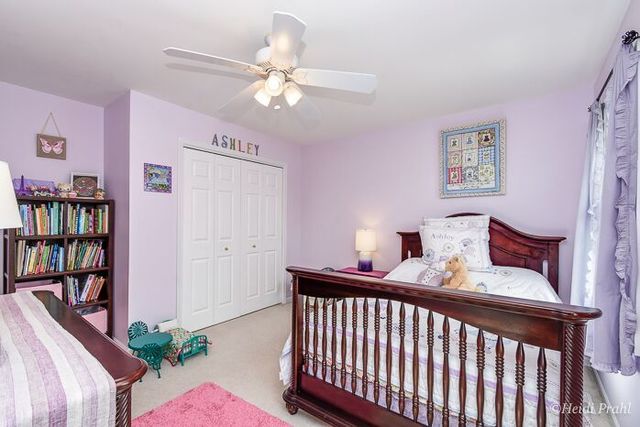 2107 Wicklow Road Naperville, IL 60564 - Photo 18 of 27 a bedroom with furniture and a chandelier