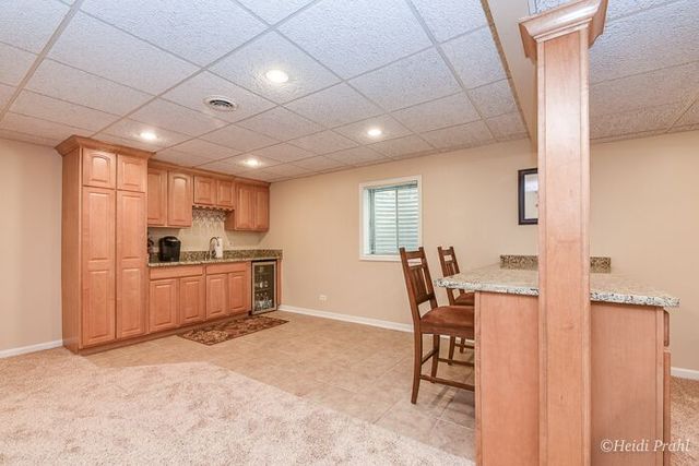 2107 Wicklow Road Naperville, IL 60564 - Photo 25 of 27 a kitchen with a table chairs refrigerator and microwave