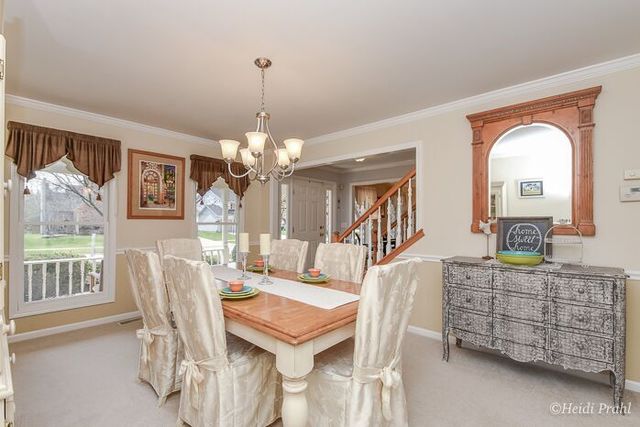 2107 Wicklow Road Naperville, IL 60564 - Photo 4 of 27 a dining room with furniture a chandelier and window