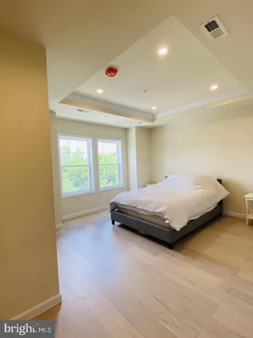 a bedroom with a bed and a large window