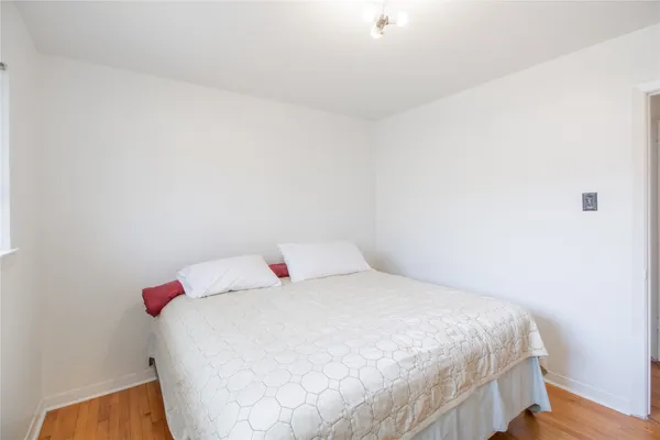 a bedroom with a bed and a white wall