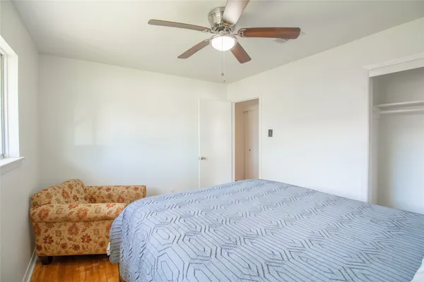 a bedroom with a bed chandelier and a window