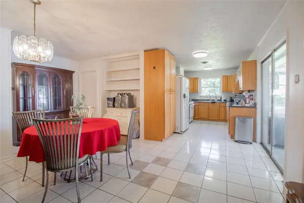 a living room with furniture a dining table and a refrigerator