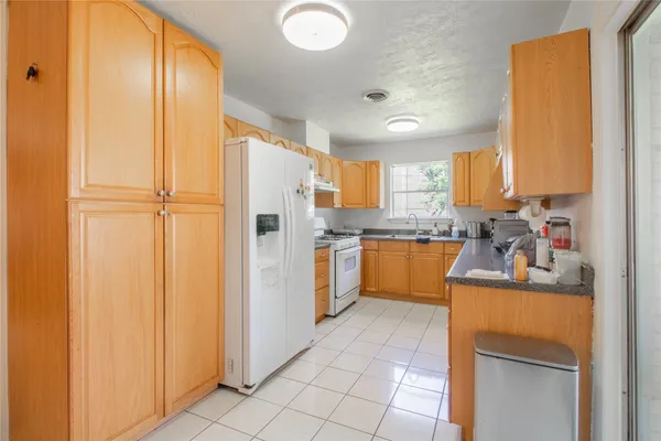 a kitchen with stainless steel appliances granite countertop a refrigerator and a stove top oven