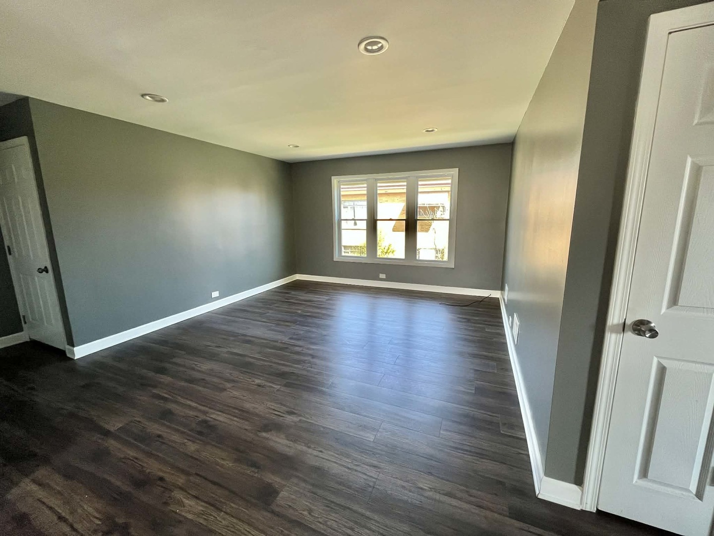 746 Walnut Street, Unit 2E Waukegan, IL 60085 - Photo 2 of 10 an empty room with wooden floor and windows