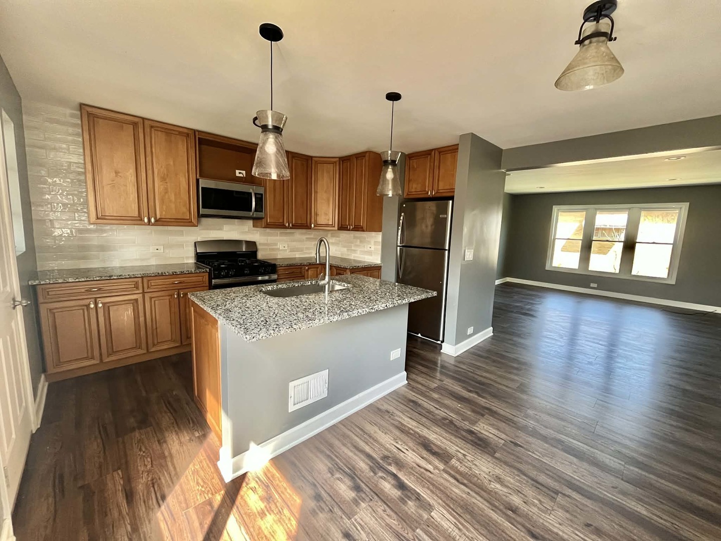 746 Walnut Street, Unit 2E Waukegan, IL 60085 - Photo 3 of 10 a large kitchen with stainless steel appliances granite countertop a stove a sink dishwasher and a refrigerator with wooden floor