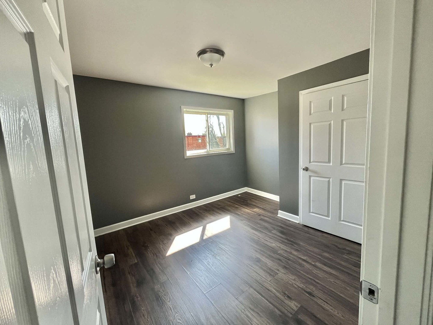 746 Walnut Street, Unit 2E Waukegan, IL 60085 - Photo 7 of 10 an empty room with wooden floor and windows