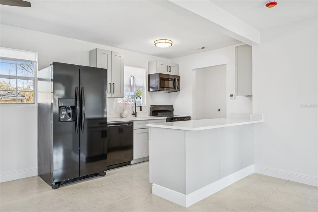 314 Wurst Road Ocoee, FL 34761 - Photo 14 of 35 a kitchen with stainless steel appliances a refrigerator and a stove top oven