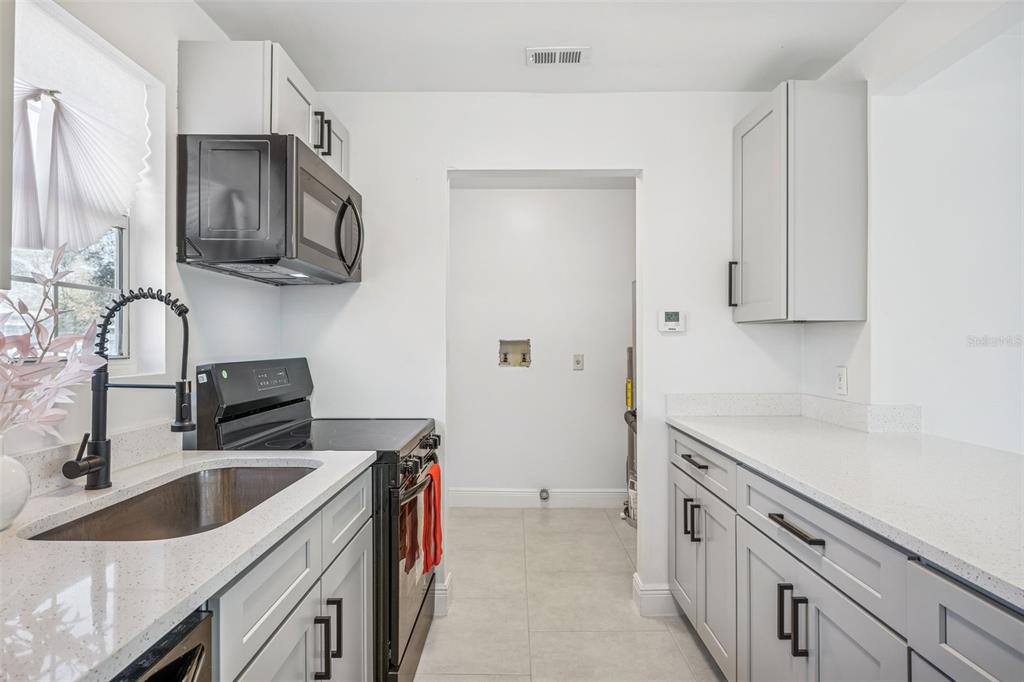 314 Wurst Road Ocoee, FL 34761 - Photo 27 of 35 a kitchen with stainless steel appliances granite countertop a sink stove microwave and refrigerator