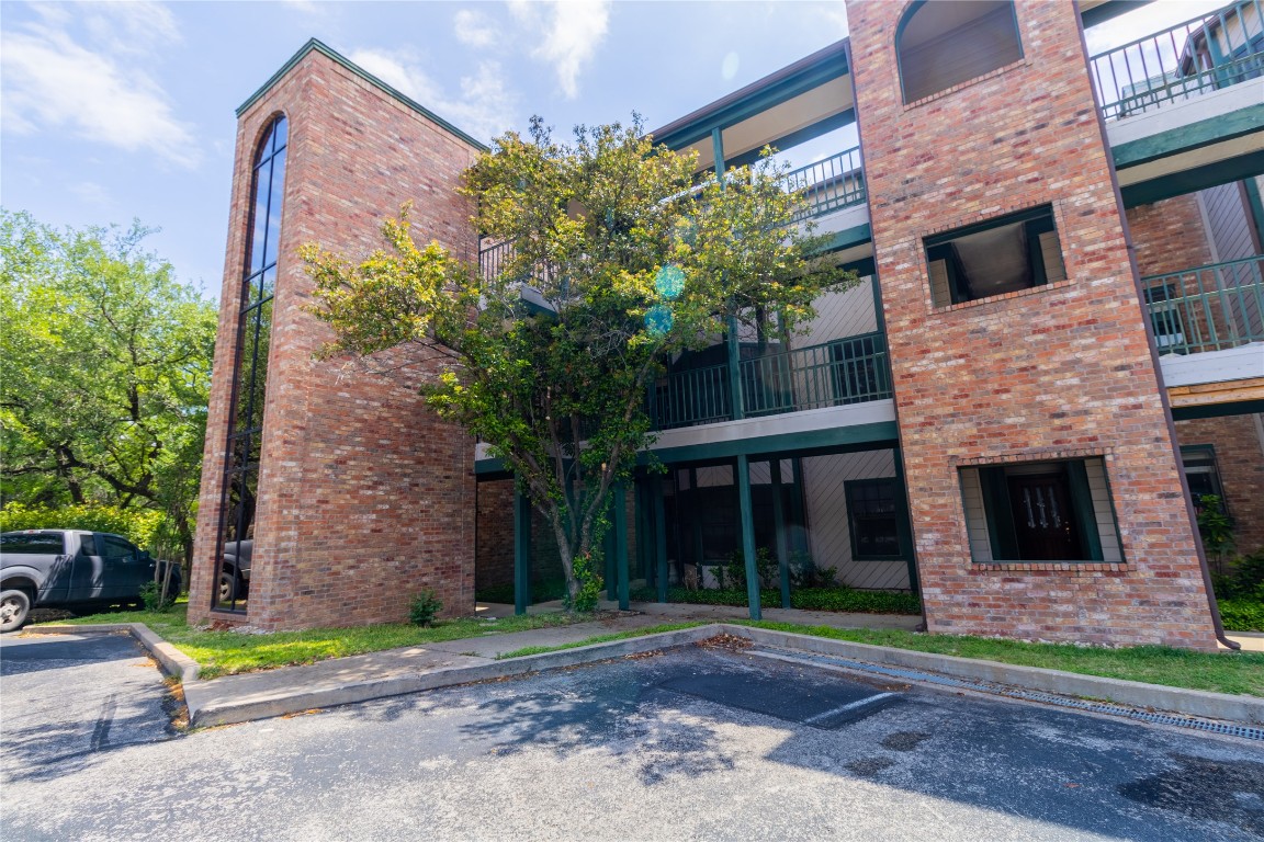 View of apartment building / complex featuring uncovered parking