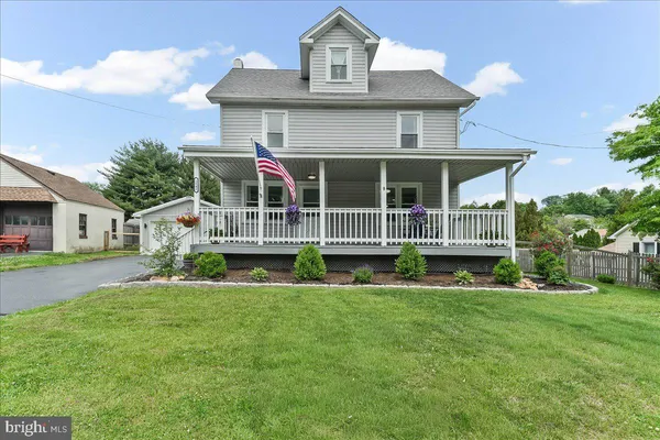 a view of house with a big yard and potted plants