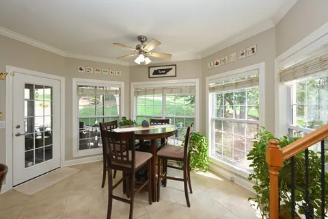 a dining room with furniture a rug and a large window