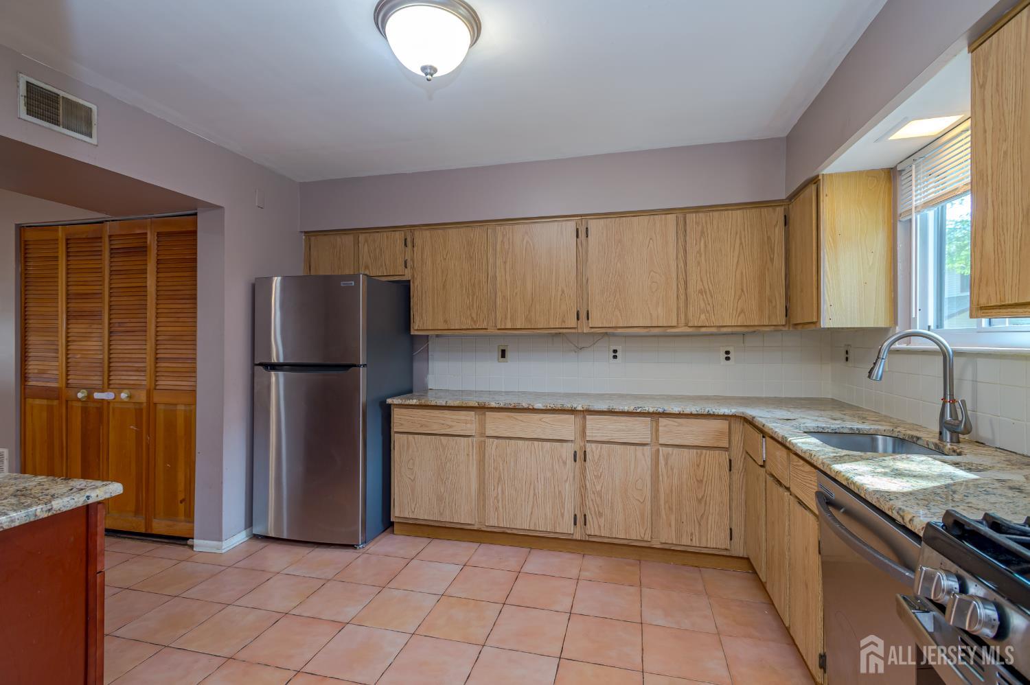 5601 Hana Road Edison, NJ 08817 - Photo 13 of 27 a kitchen with a sink a refrigerator and cabinets