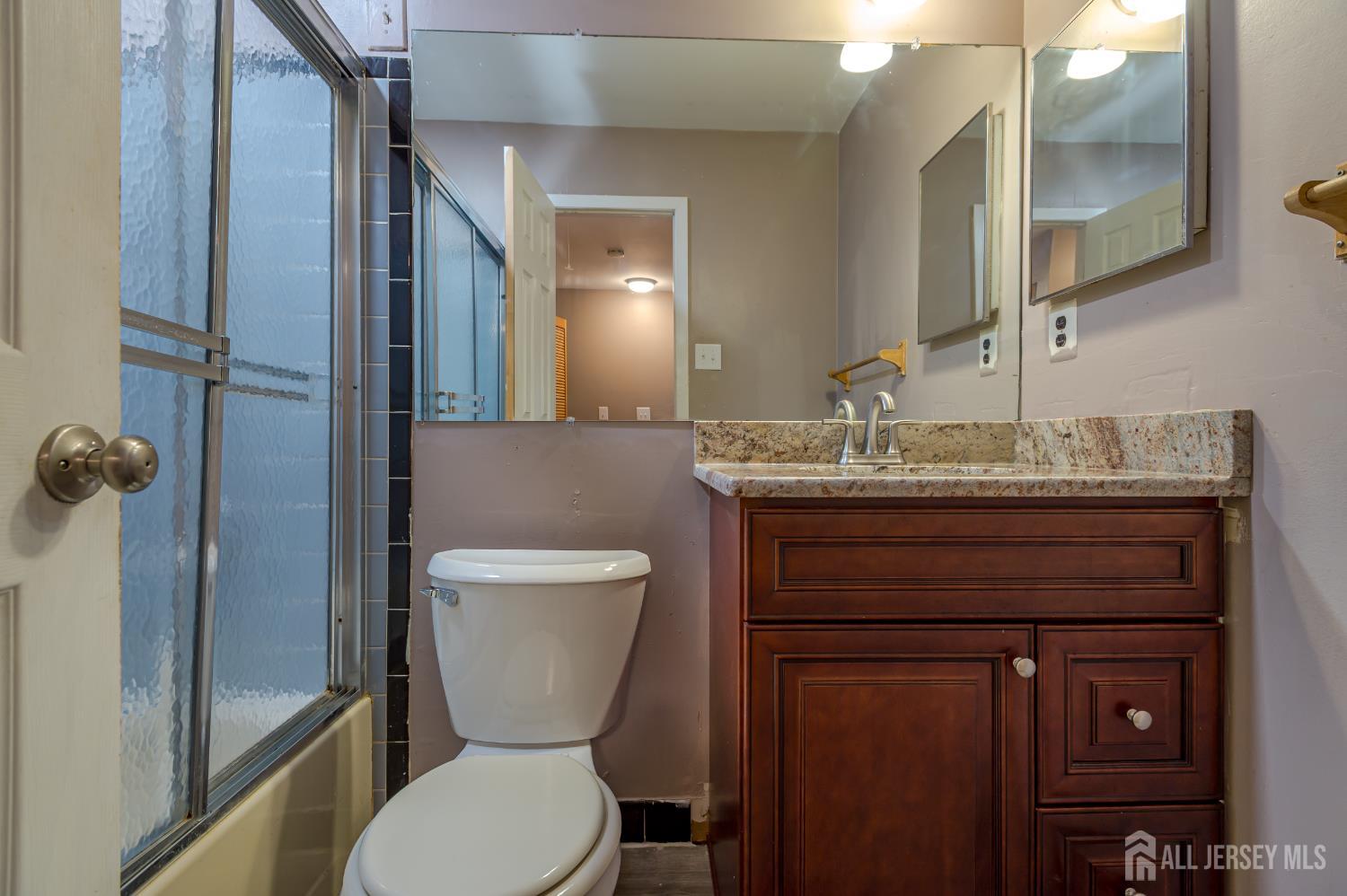5601 Hana Road Edison, NJ 08817 - Photo 21 of 27 a bathroom with a toilet sink and mirror