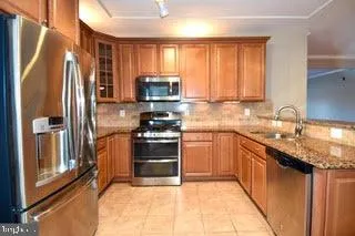 a kitchen with granite countertop a refrigerator stove top oven and sink