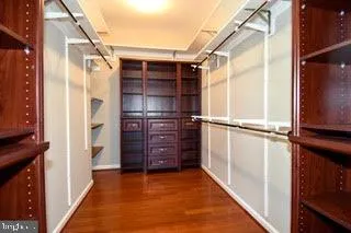 a view of walk in closet with wooden floor