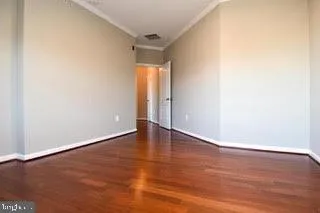 a view of an empty room with wooden floor