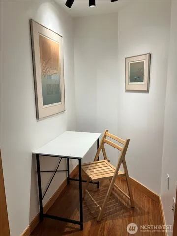 a view of a workspace with furniture and wooden floor