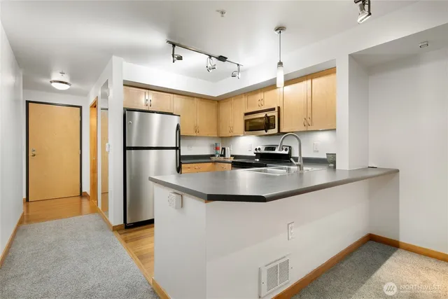 a kitchen with stainless steel appliances granite countertop a refrigerator a microwave a sink and a stove