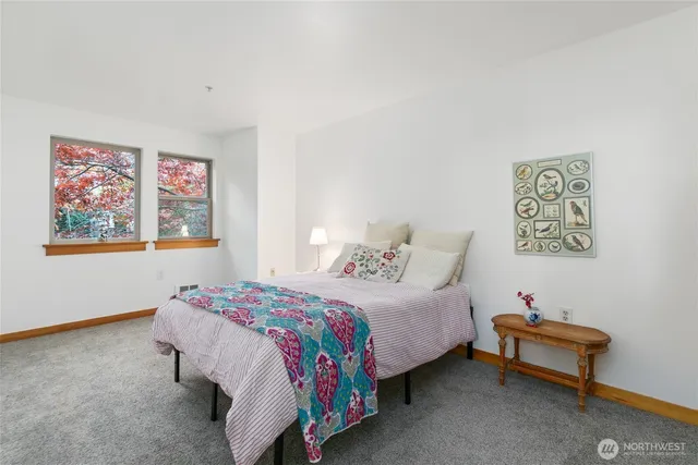 a bedroom with a bed and a painting on the wall