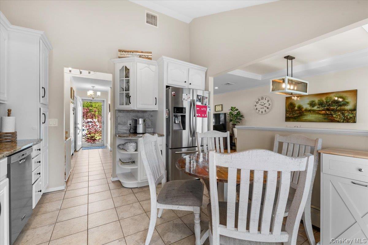 61 Winthrop Road Plainview, NY 11803 - Photo 11 of 37 a kitchen with white cabinets and stainless steel appliances