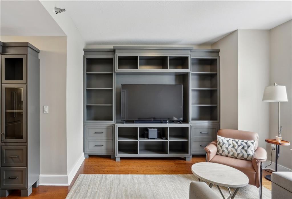 285 Centennial Olympic Park Drive Northwest, Unit 1209 Atlanta, GA 30313 - Photo 3 of 17 a living room with furniture and a bookshelf