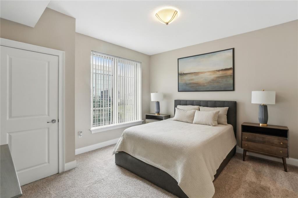 285 Centennial Olympic Park Drive Northwest, Unit 1209 Atlanta, GA 30313 - Photo 5 of 17 a bedroom with a bed and a lamp