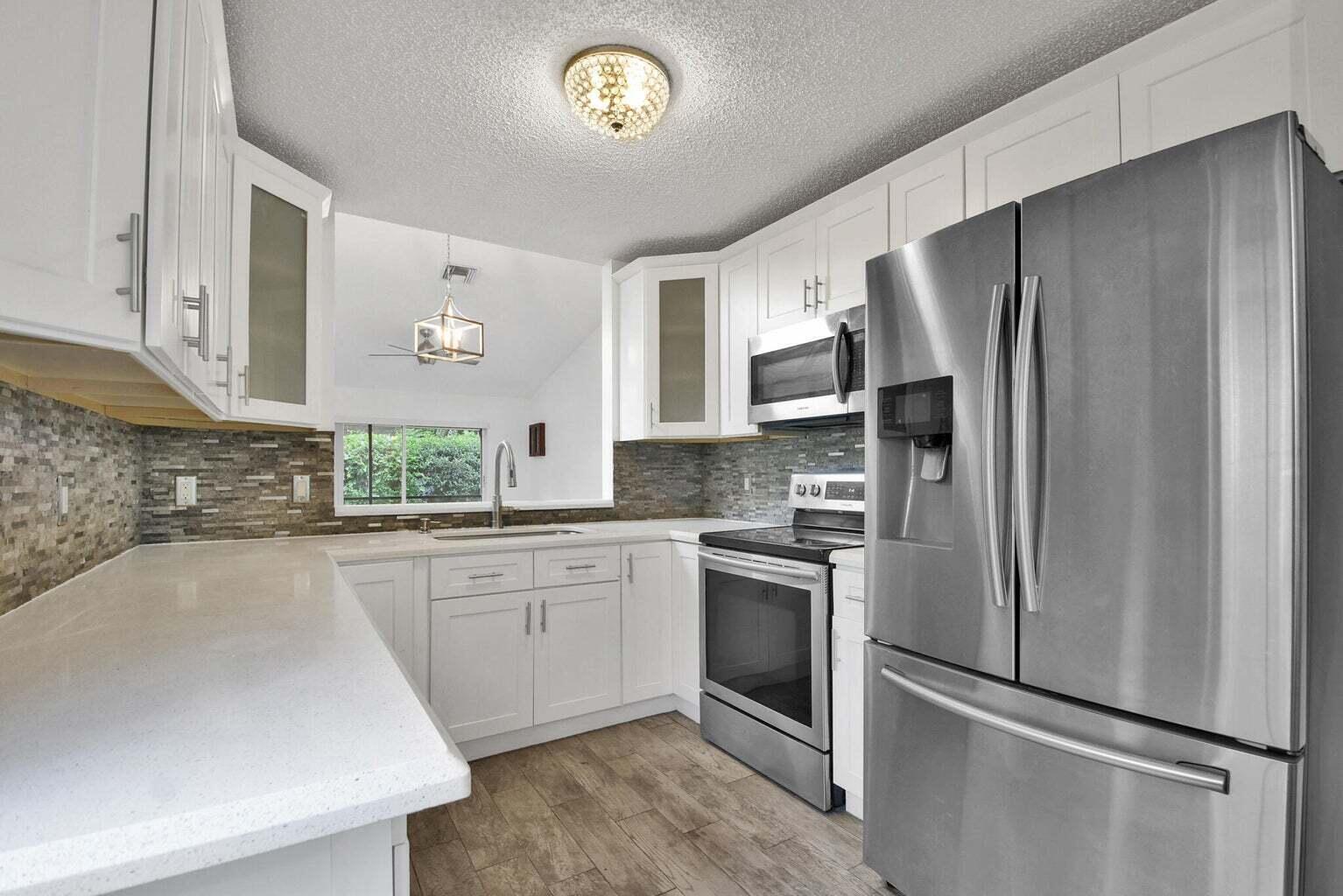 13175 Quiet Woods Road, Unit A Wellington, FL 33414 - Photo 23 of 46 a kitchen with a refrigerator and a sink