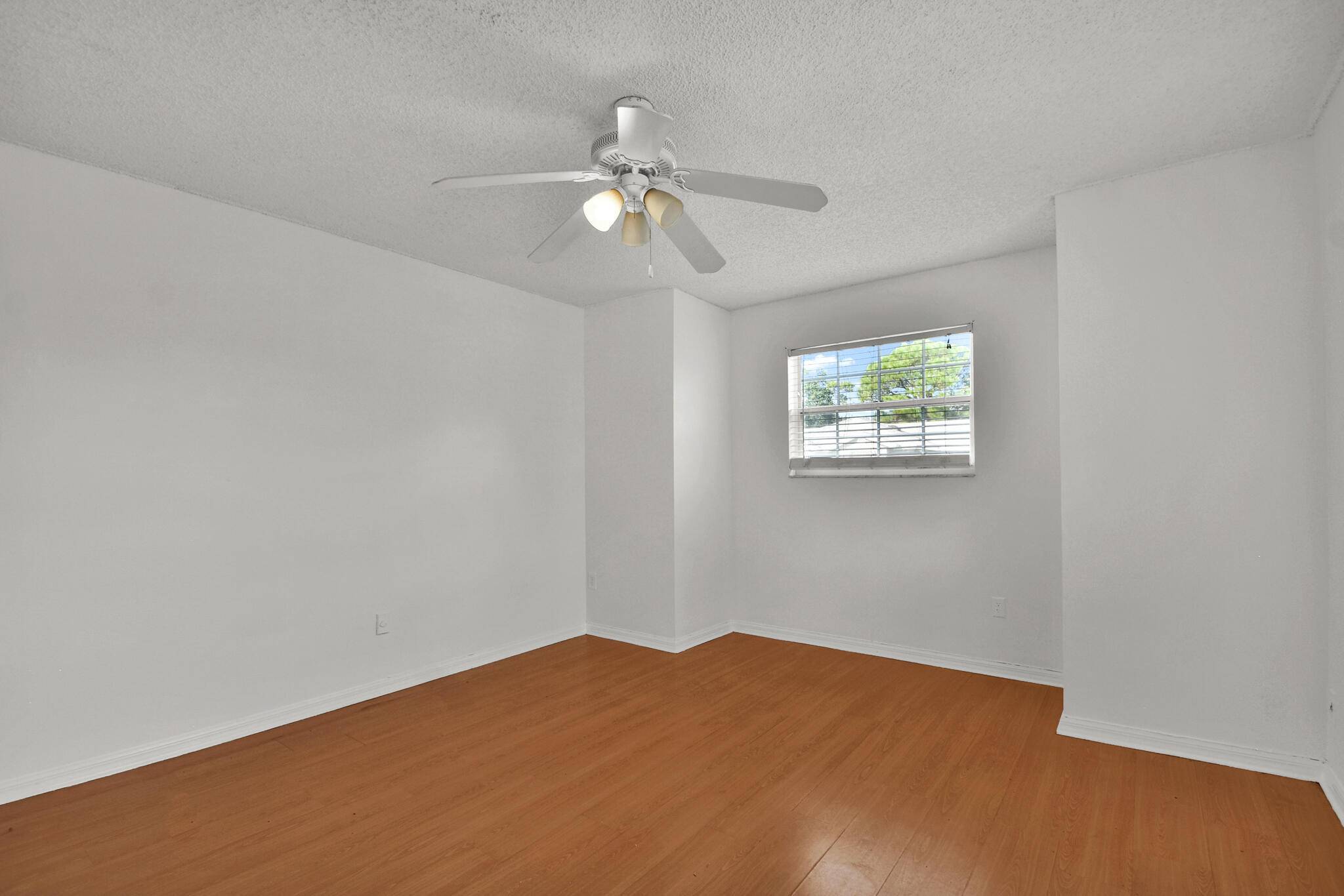 13175 Quiet Woods Road, Unit A Wellington, FL 33414 - Photo 28 of 46 a view of a big room with wooden floor and chandelier fan