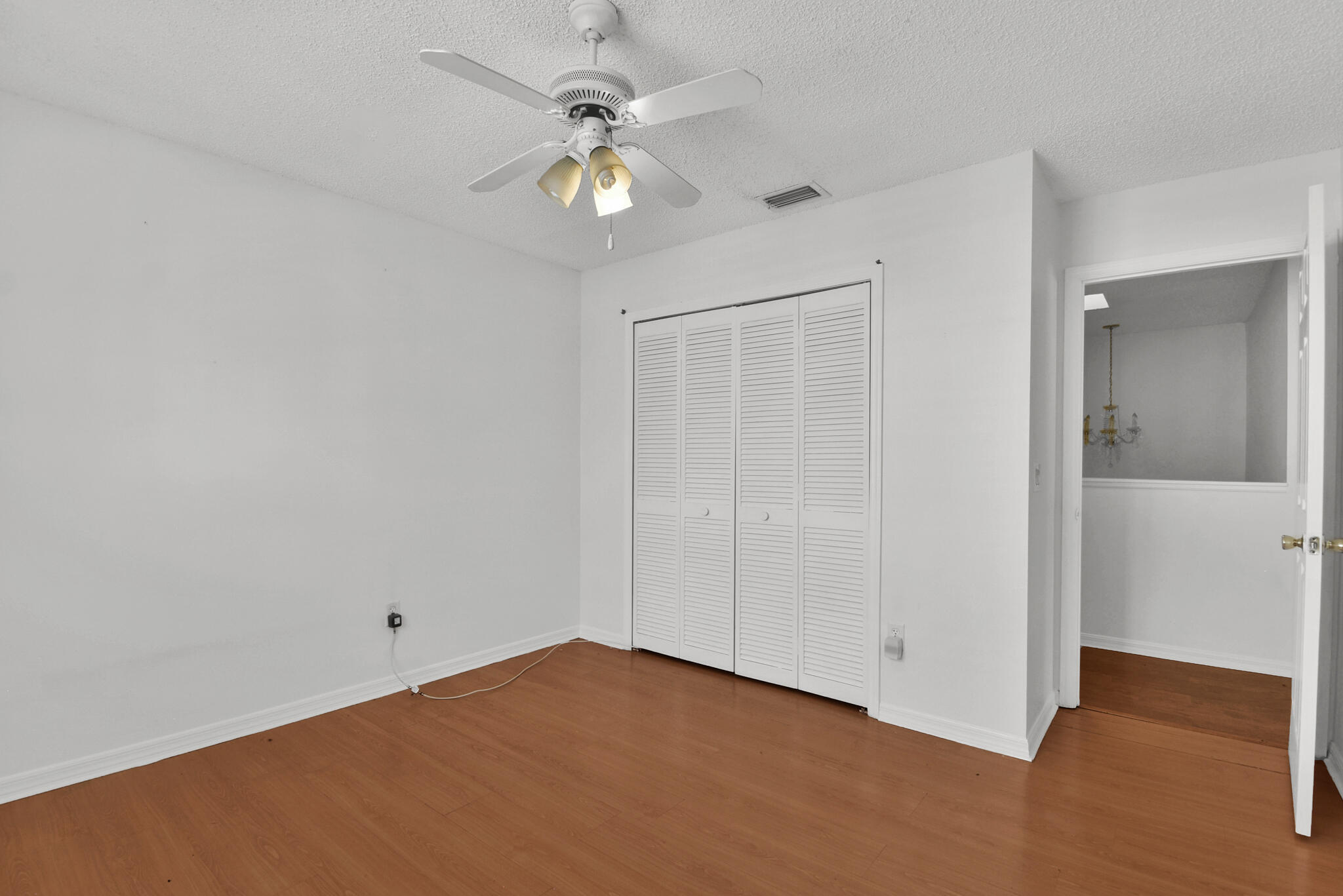 13175 Quiet Woods Road, Unit A Wellington, FL 33414 - Photo 33 of 46 an empty room with a chandelier fan and windows