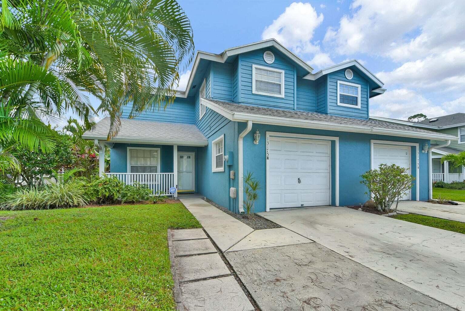 13175 Quiet Woods Road, Unit A Wellington, FL 33414 - Photo 4 of 46 a front view of a house with a yard and garage
