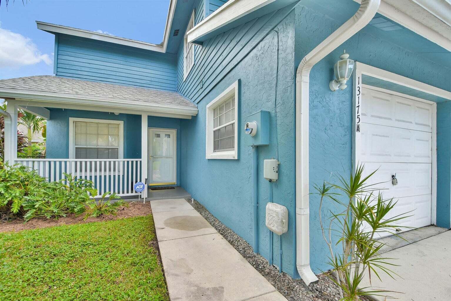 13175 Quiet Woods Road, Unit A Wellington, FL 33414 - Photo 5 of 46 a view of a house with a small yard and plants