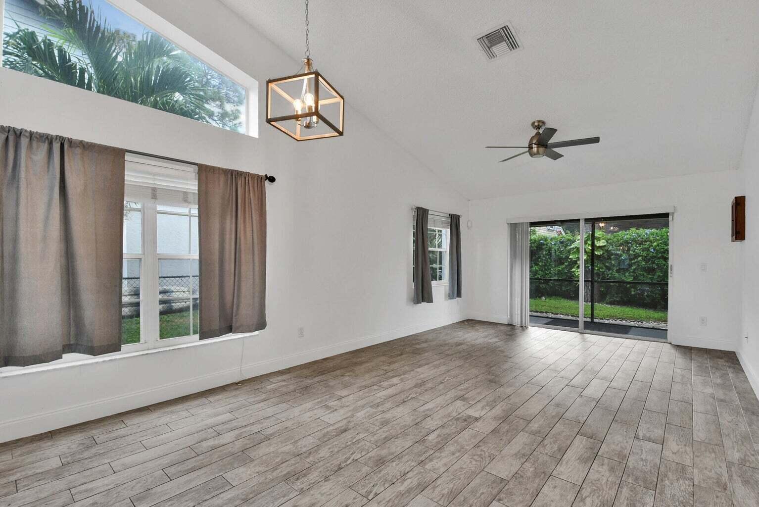 13175 Quiet Woods Road, Unit A Wellington, FL 33414 - Photo 6 of 46 a view of an empty room with wooden floor and a window