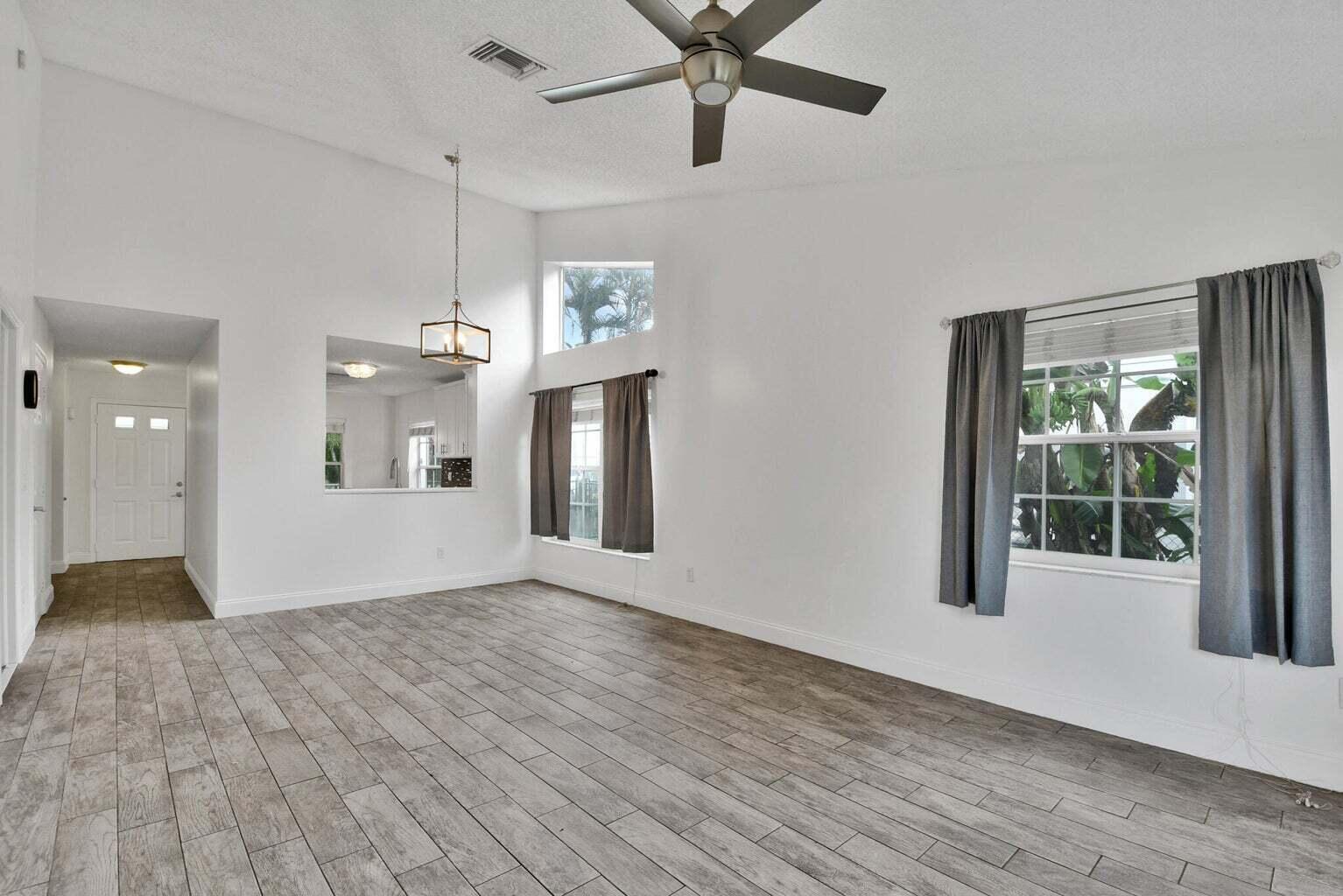 13175 Quiet Woods Road, Unit A Wellington, FL 33414 - Photo 10 of 46 a view of empty room with wooden floor and fan