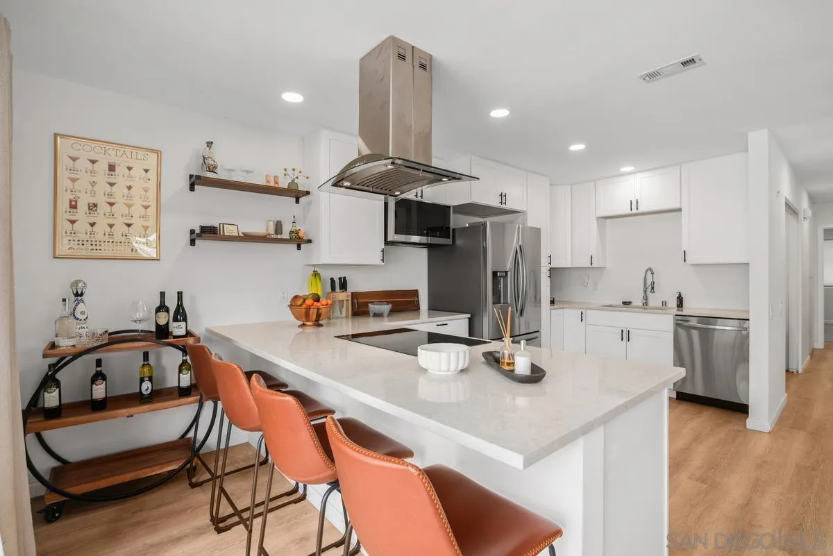 a kitchen with stainless steel appliances a sink a stove a refrigerator and cabinets