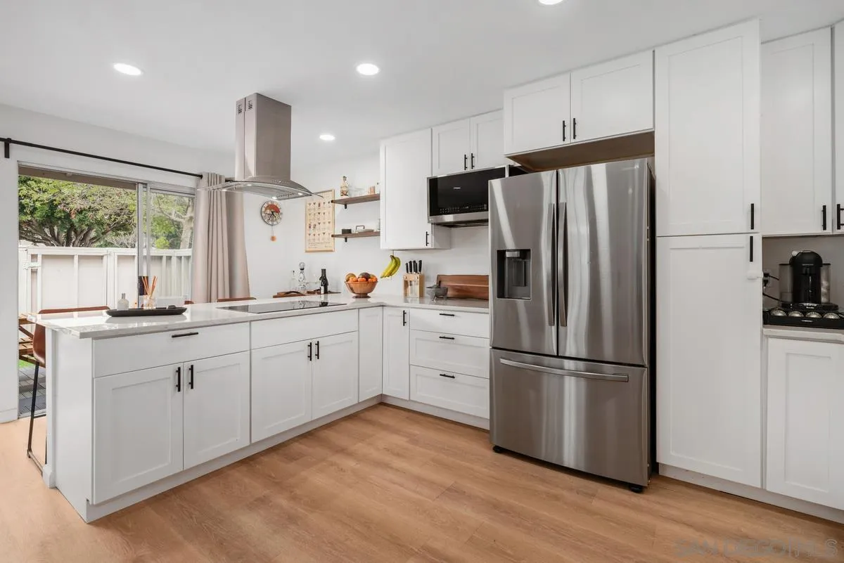 751 Pyramid Point Way Oceanside, CA 92058 - Photo 11 of 30 a kitchen with white cabinets stainless steel appliances and window