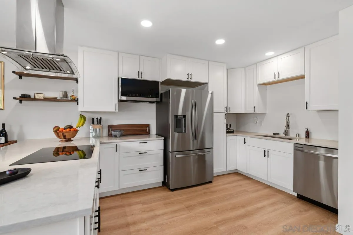 751 Pyramid Point Way Oceanside, CA 92058 - Photo 12 of 30 a kitchen with white cabinets and stainless steel appliances