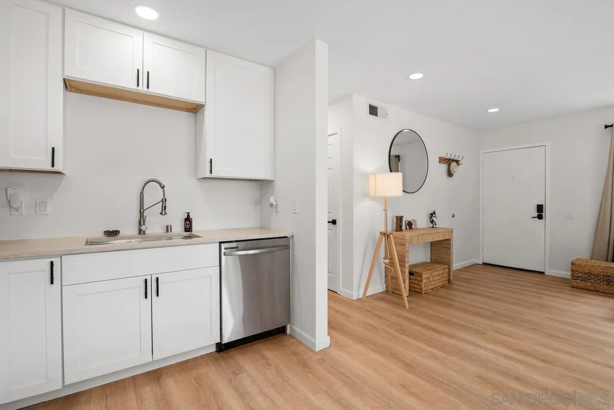 751 Pyramid Point Way Oceanside, CA 92058 - Photo 13 of 30 a kitchen with sink cabinets and wooden floor