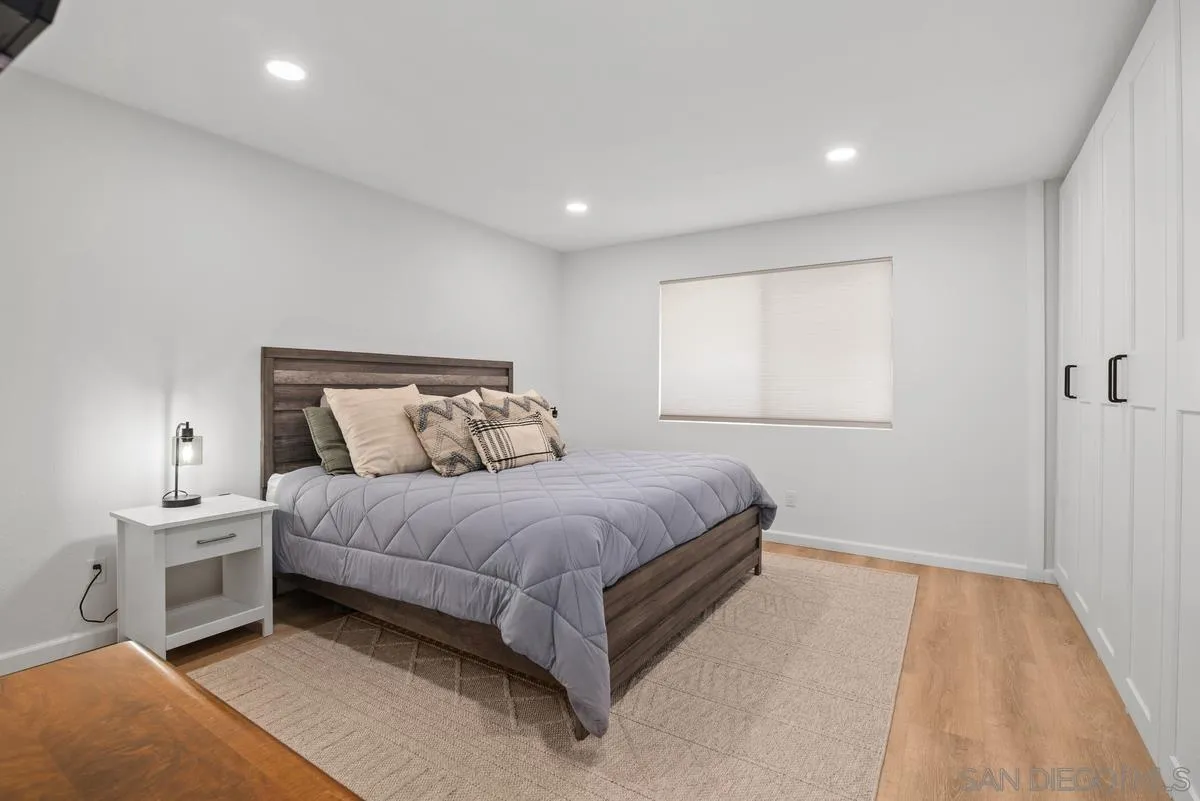 751 Pyramid Point Way Oceanside, CA 92058 - Photo 17 of 30 a spacious bedroom with a bed and a lamp