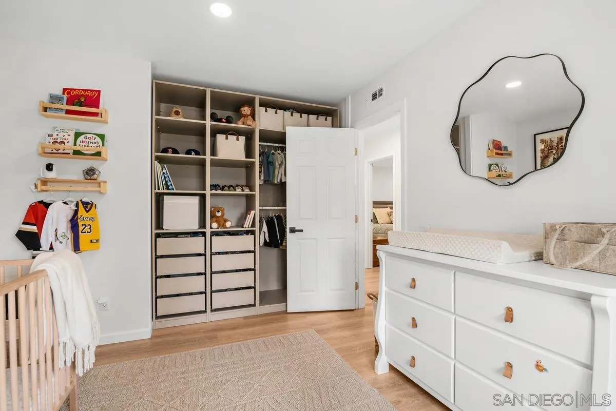 751 Pyramid Point Way Oceanside, CA 92058 - Photo 22 of 30 a view of a bedroom with baby crib and cabinet