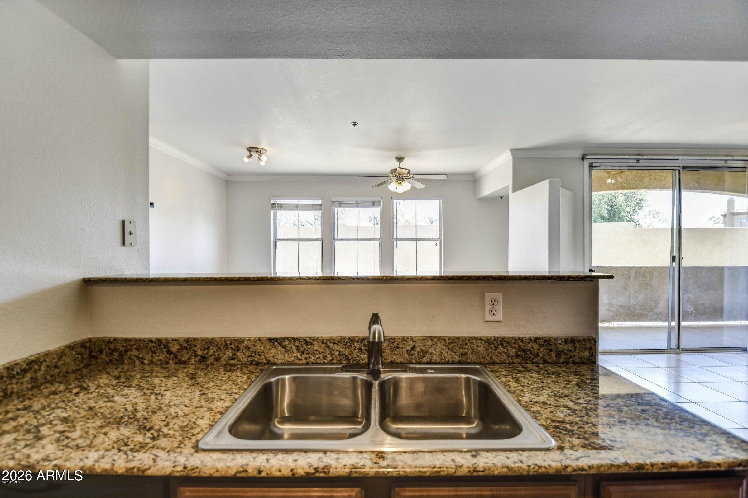 2134 East Broadway Road, Unit 1039 Tempe, AZ 85282 - Photo 11 of 24 a kitchen with a sink a counter top space cabinets and stainless steel appliances