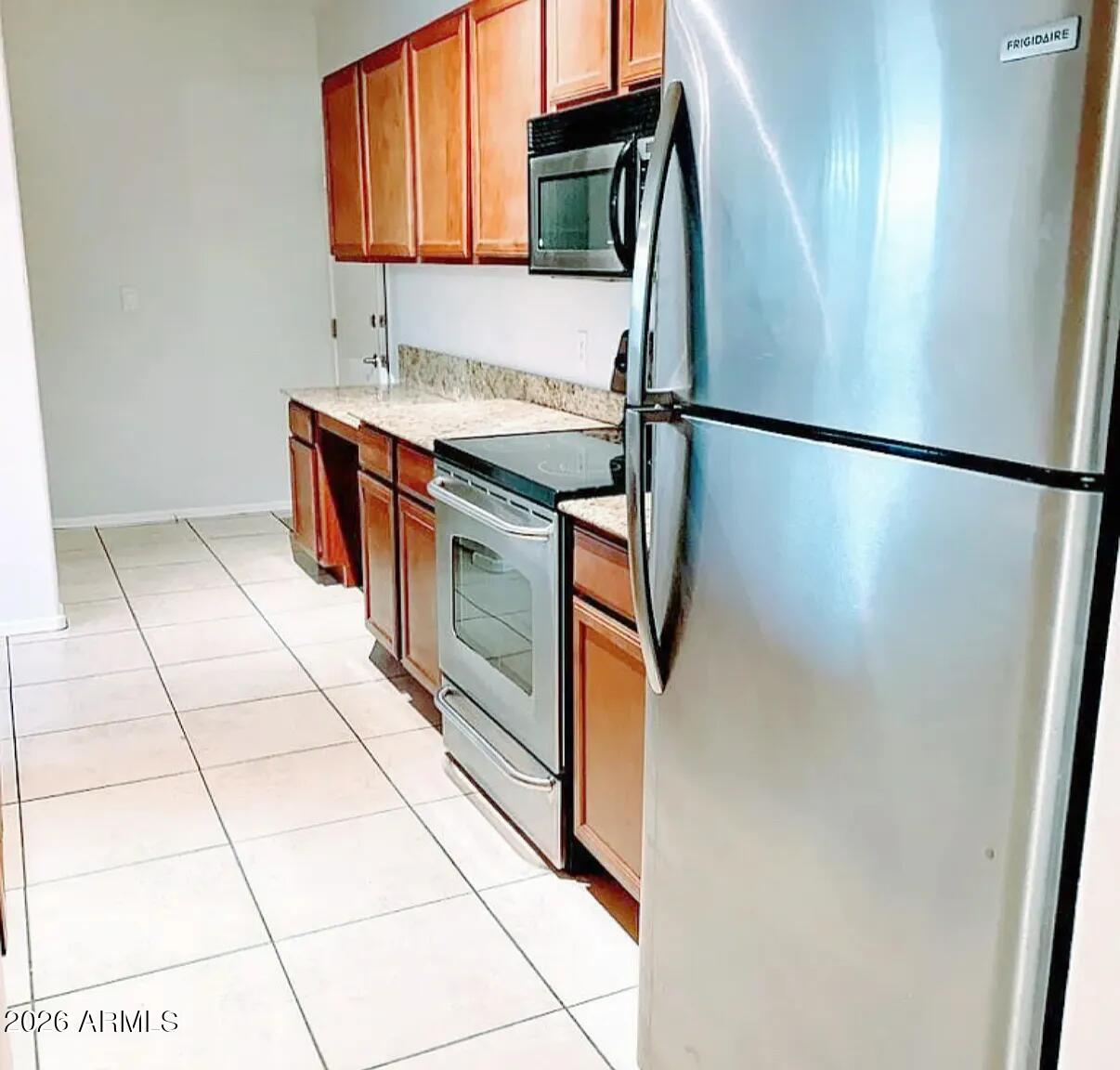 2134 East Broadway Road, Unit 1039 Tempe, AZ 85282 - Photo 14 of 24 a kitchen with stainless steel appliances granite countertop a refrigerator a sink and a stove