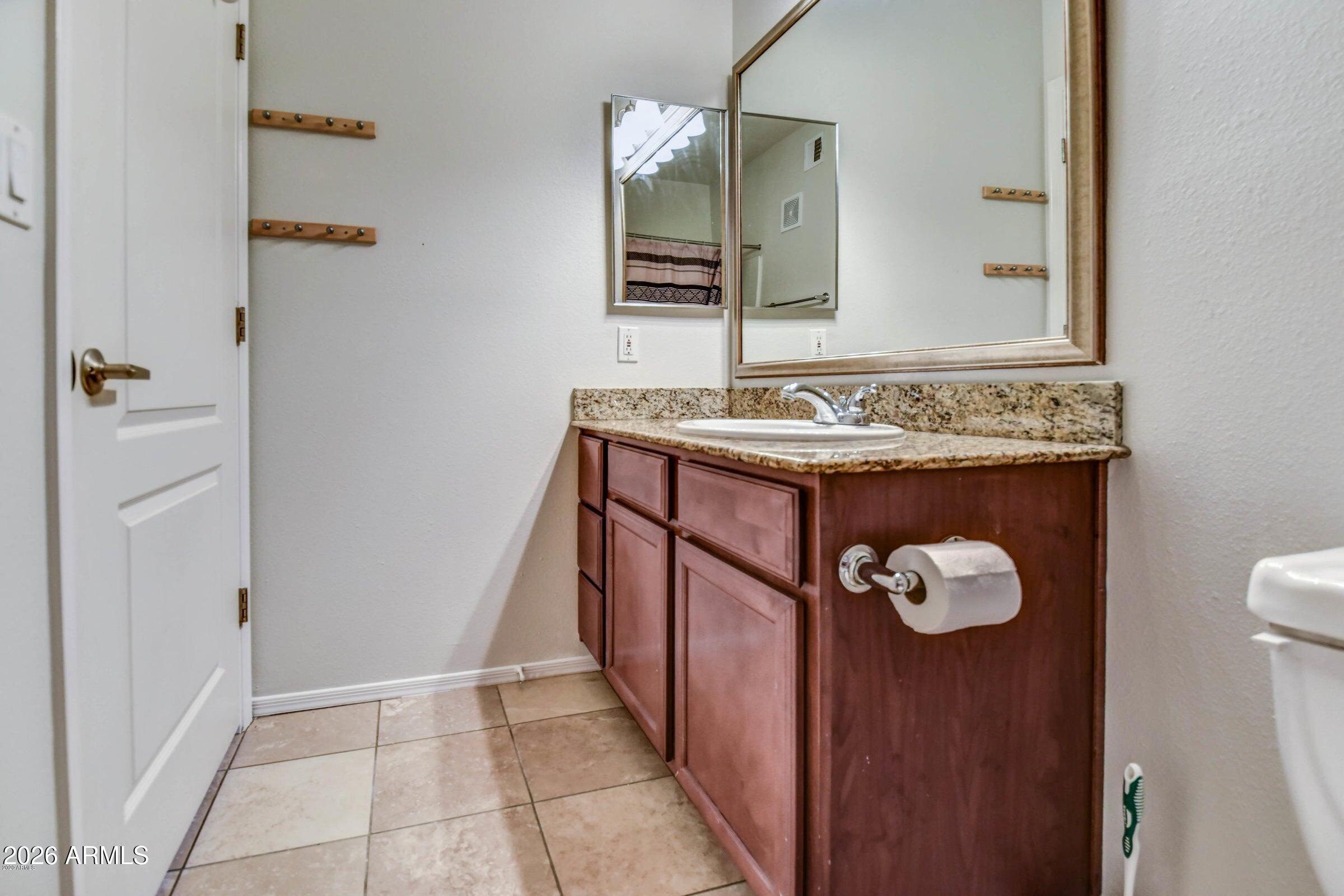 2134 East Broadway Road, Unit 1039 Tempe, AZ 85282 - Photo 20 of 24 a bathroom with a granite countertop sink and a mirror