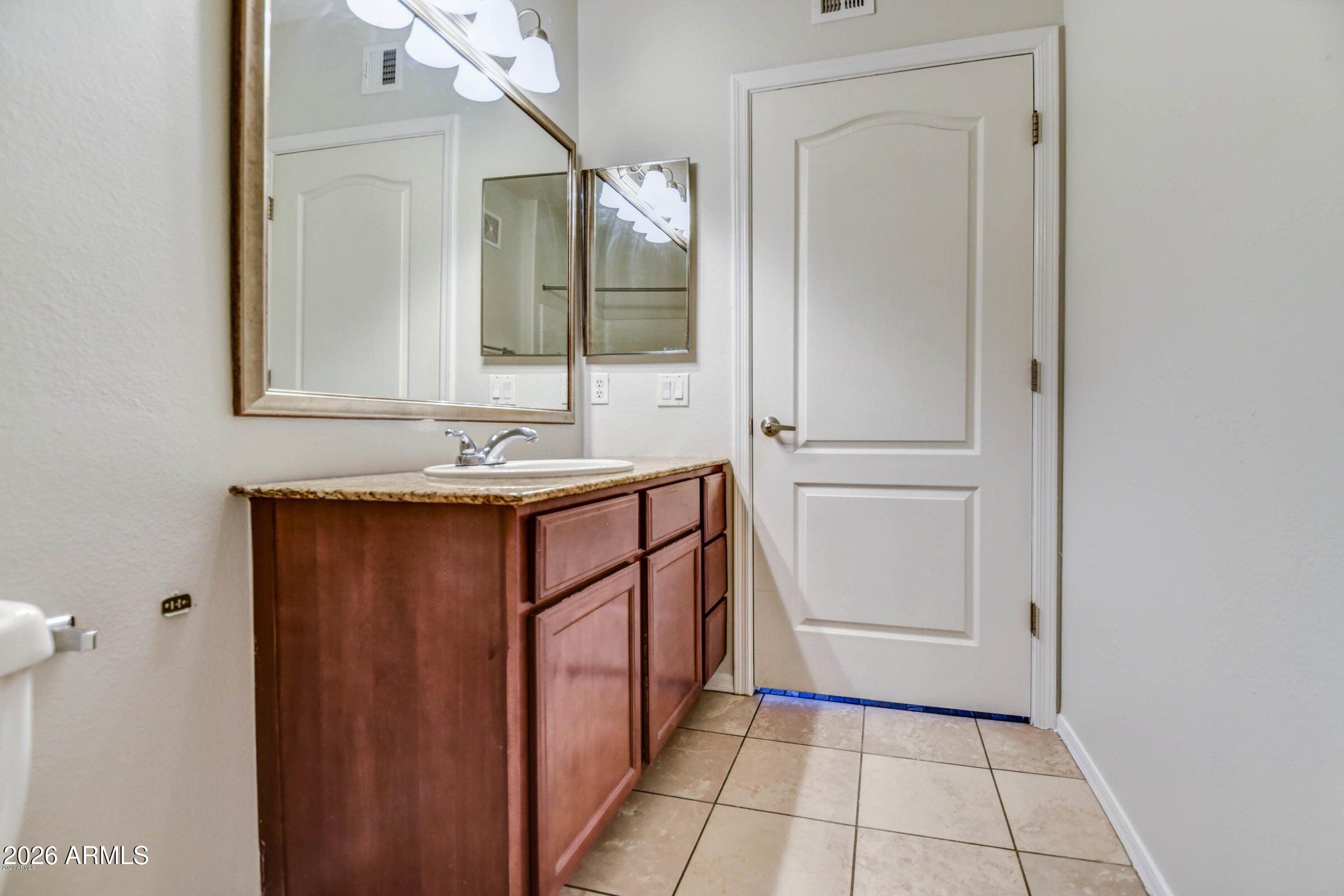 2134 East Broadway Road, Unit 1039 Tempe, AZ 85282 - Photo 21 of 24 a bathroom with a sink a mirror and a vanity