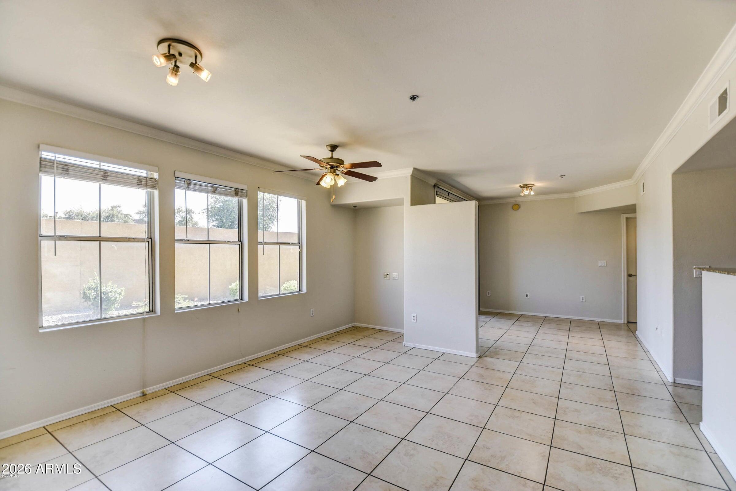 2134 East Broadway Road, Unit 1039 Tempe, AZ 85282 - Photo 4 of 24 a view of an empty room with window and chandelier fan